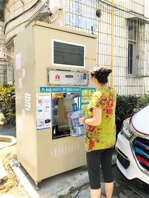 5月24日，瓊山區(qū)上丹花苑小區(qū)居民陳女士在使用共享凈水機(jī)取水。 本報(bào)記者 陳歆卓 攝